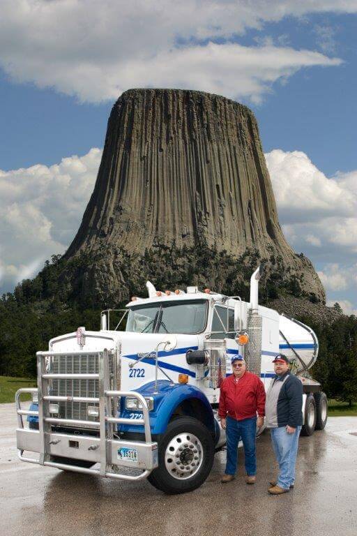 Dixon Bros and a fleet vehicle in fron t of Devil's Tower, WY.